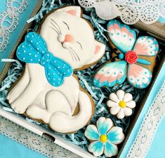 decorated cookies in a box with lace doily on the edge and butterfly decorations around it