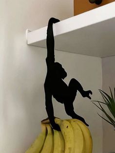 a monkey figurine sitting on top of some bananas