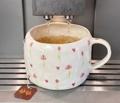 a coffee cup filled with liquid sitting on top of a counter next to a card