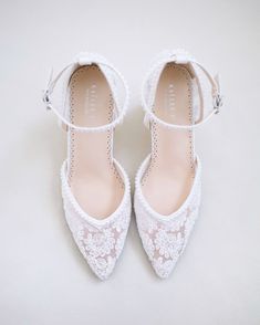 a pair of white shoes with lace on them