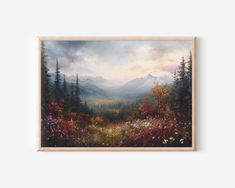 a painting hanging on the wall above a wooden frame with flowers and mountains in the background