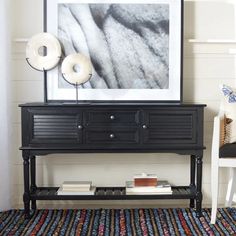 a black dresser with two donuts sitting on top of it next to a white chair