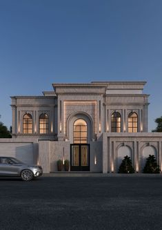 a car is parked in front of a large white building with arched windows and doors