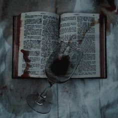 an open book and wine glass on a table