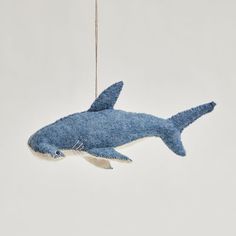 an ornament shaped like a shark hanging from a rope