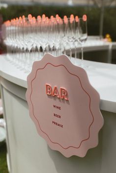 there is a sign that says bar next to some wine glasses