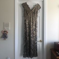 a dress hanging on a door with a teddy bear in the corner next to it