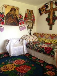 a room with two beds and paintings on the wall above them, along with rugs