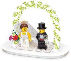 a lego wedding cake topper with a bride and groom in front of an arch