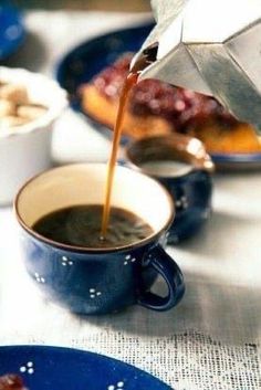 coffee being poured into a cup on a table