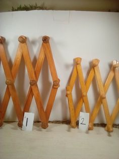 three wooden pegs are lined up against the wall with numbered numbers on each side