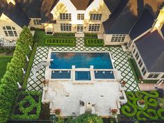 an aerial view of a large home with a pool and landscaping around the perimeters