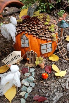 there is a small house made out of pumpkins and other decorations on the ground