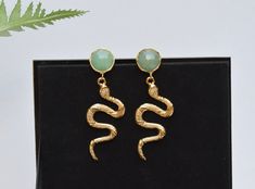 These snake earrings are so sssssssstriking!  Featuring a Jade green earring post and a 24K gold plated snake pendant, they are unique and definitely a statement piece. Snake jewellery is believed to be associated with protection and healing and were used in Greek mythology to represent renewal, growth and fertility.  MATERIALS: ▪️ 24K gold plated Jade gemstone earring ▪️ 24K gold plated snake pendant over brass ▪️ Lead and nickel free DIMENSIONS: Length - 6.5 cm Width - 1.5 cm *If these earrings are being purchased as a gift, please contact me with the message you would like written on the card. Handmade Gold Snake Earrings, Gold Snake-shaped Earrings For Gift, Gold Snake Earrings, Snake Jewellery, Green Earring, Snake Pendant, Jade Gemstone, Snake Jewelry, Snake Earrings