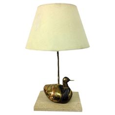 a brass duck lamp on a marble base