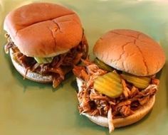 two pulled pork sandwiches with pickles on them