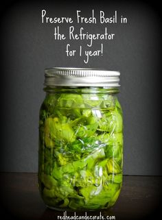 a jar filled with green vegetables sitting on top of a table