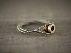 This is a unique and budget friendly guitar string engagement style ring! The string is nickle guitar string, so it has a silver looking color. Nickel does not corrode or discolor your finger, so it is great for long term consistent use. It is wrapped around itself 3 times, holding a brass ball end from a bass guitar string. It would work great as an engagement ring, purity ring, or to wear simply because you love guitar or love someone who does! Can be made to any size :)Here are some cool matc Manly Jewelry, Music Rings, Diy Leather Working, Fork Ring, Guitar Jewelry, Guitar String Jewelry, Object Sculpture, Uncle Jesse, Guitar String Bracelet