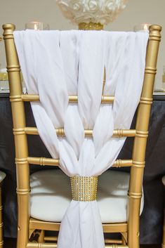 the chair is decorated with gold and white linens