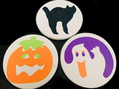 three halloween buttons with cats and pumpkins on them, all decorated in different colors