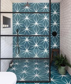 a bathroom with blue and white tiles on the walls, flooring and shower stall