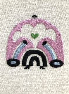 the embroidery design shows an image of a rainbow and two birds on top of each other