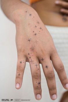 a woman's hand with stars tattooed on it