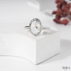 a white diamond ring sitting on top of a box