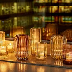 candles are lined up on a window sill in front of a cityscape