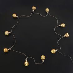 a string of gold and silver balls on a black background