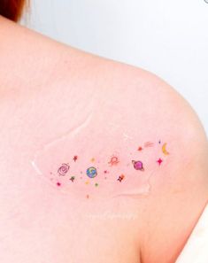 the back of a woman's shoulder with stars and planets on it