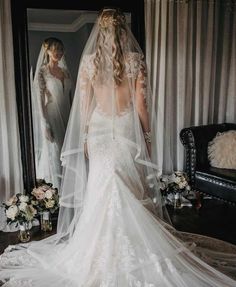 the back of a bride's wedding dress in front of a mirror