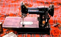 an old sewing machine sitting on top of a bed