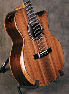 an acoustic guitar sitting on top of a stand