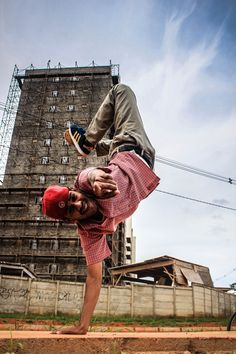 a man doing a handstand in front of a tall building