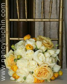 a bouquet of white and yellow flowers sitting on a chair with gold trimmings