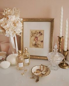 a table topped with candles and vases filled with flowers next to a framed photograph