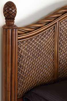 the headboard and foot board of a bed made out of wicker with a wooden post