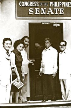 black and white photograph of four people standing in front of a building that says congress of the philippines