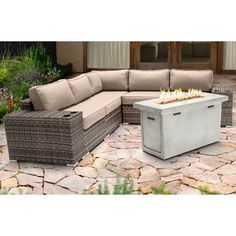 a fire pit sitting on top of a stone floor next to a couch and table