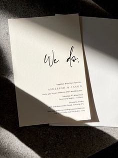 two wedding cards with the word we do written in black ink on top of them