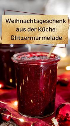 a glass jar filled with red liquid sitting on top of a table next to christmas decorations