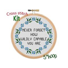 the cross stitch kit has been designed to look like a wreath with blue flowers on it