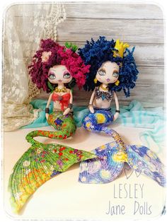 two little mermaid dolls sitting next to each other