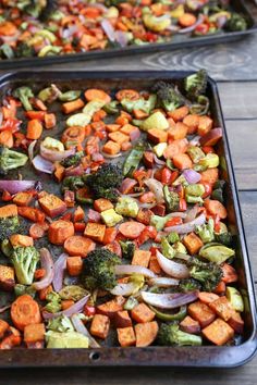 two pans filled with vegetables on top of a wooden table next to each other