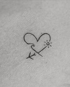 a small heart and arrow tattoo on the back of a woman's left arm