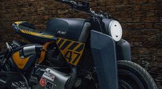 a yellow and black motorcycle parked in front of a brick wall