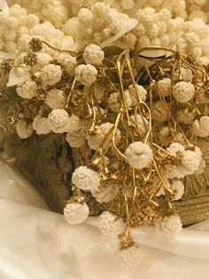 a bunch of white flowers sitting on top of a table next to a book and candle