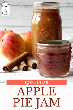 an apple pie jam in a jar with cinnamon sticks and apples around it on a white wooden table