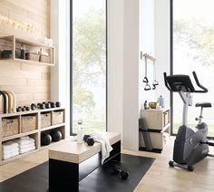 there is a gym with exercise equipment in the room and towels on the rack next to it